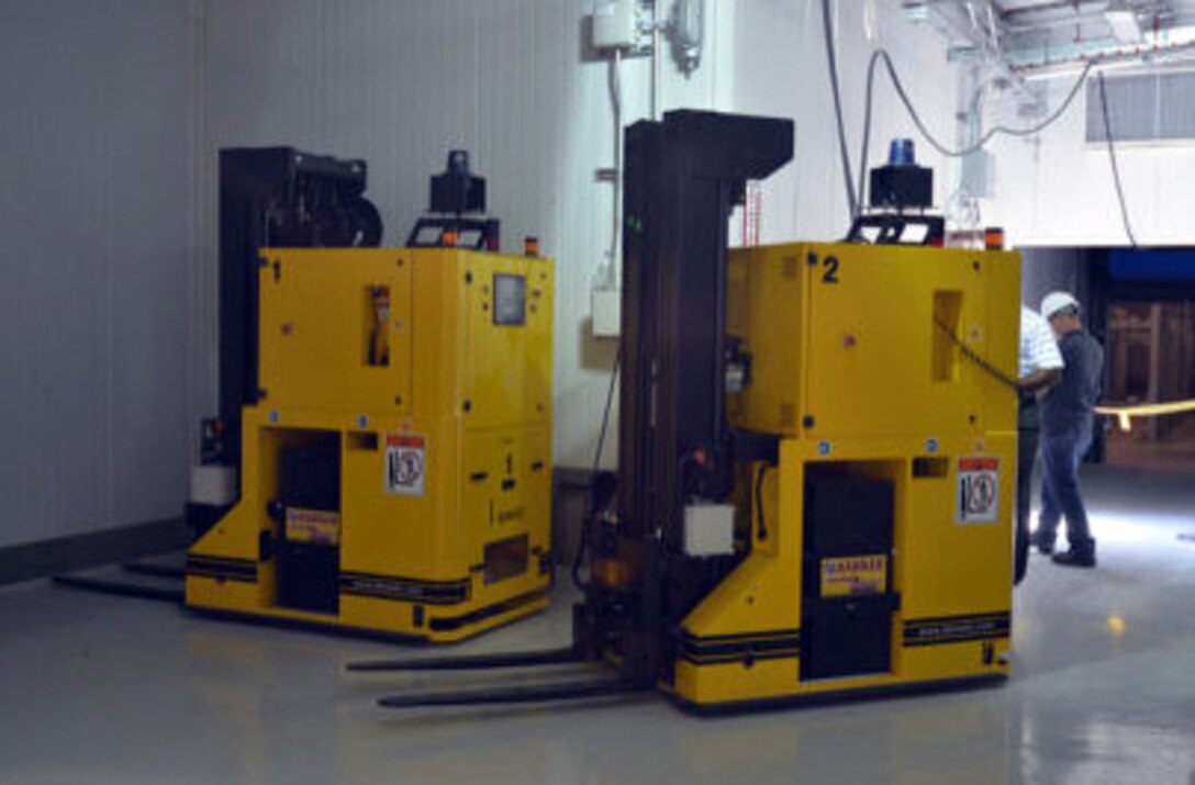 Two large yellow machines sit on the floor.