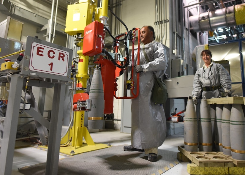 A man in a hazard suit operates machinery.