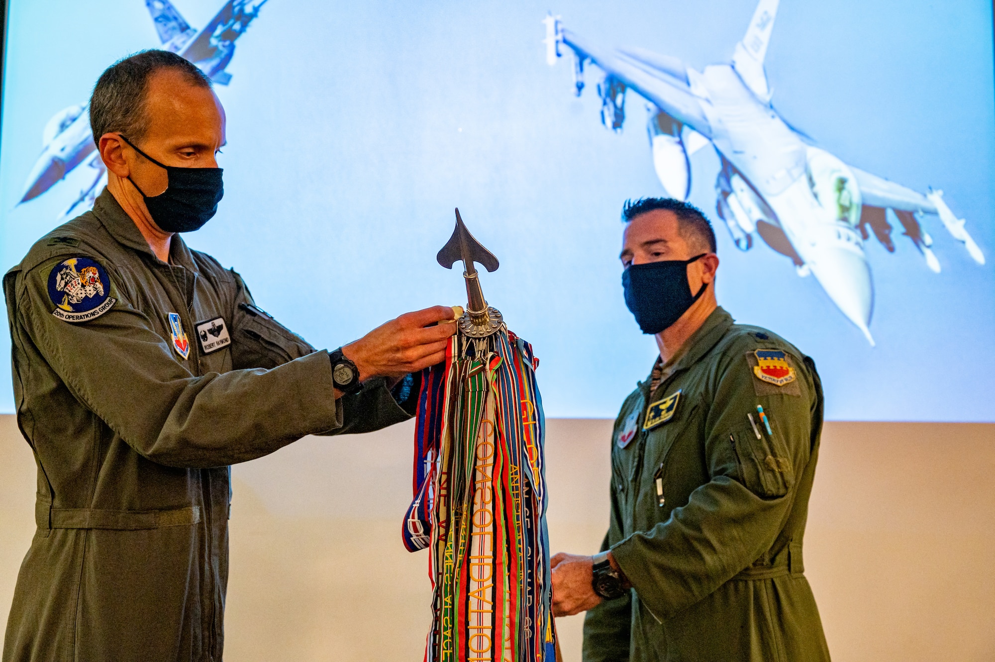 A photo of two Airmen holding a guidon flag.