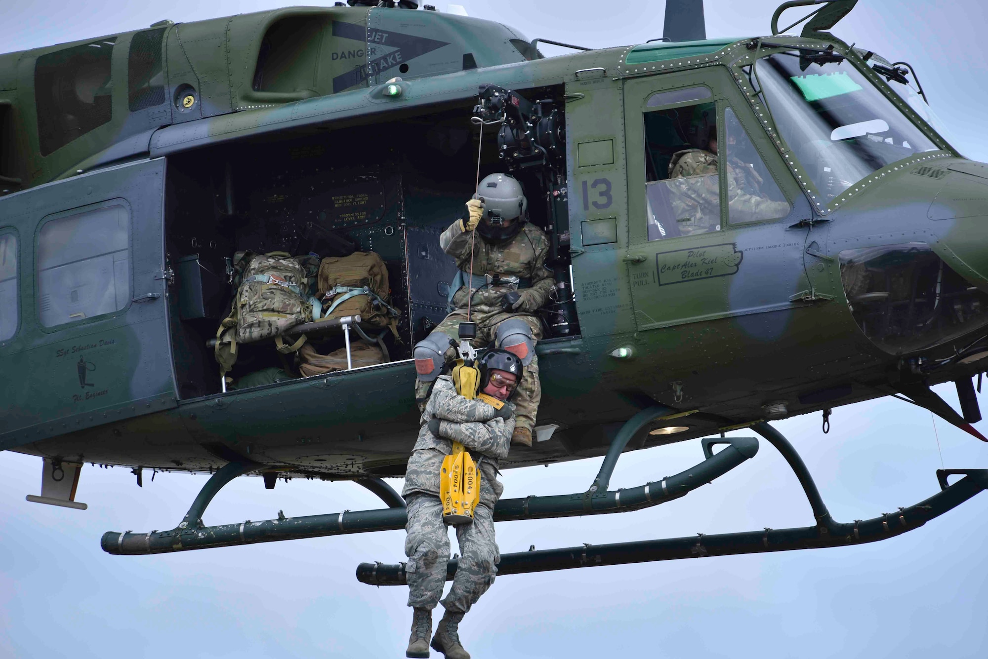 A student from the Survival, Evasion, Resistance and Escape school is hoisted into a Bell UH-1N Iroquois helicopter from the 36th Rescue Squadron at Fairchild Air Force Base, Washington, Jan. 30, 2020. The mission of the 36th RQS is to provide training and support to the Airmen working and training at the SERE school and to help the local community with search and rescue operations. (U.S. Air Force photo by 1st Class Airman Kiaundra Miller)