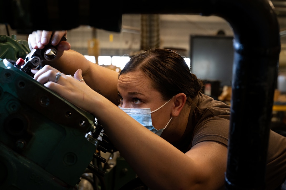 A Sailor practices putting a marine engine aback together at the Maritime & Intermodal Training Center.