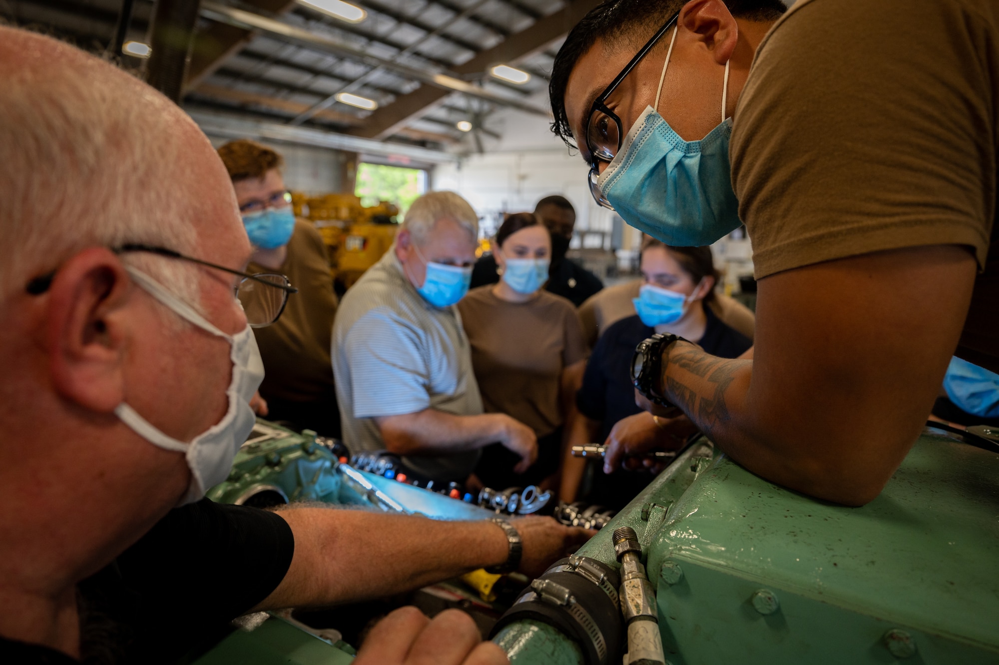 Marine engineering instructors give a hands on lesson to Navy Sailors.