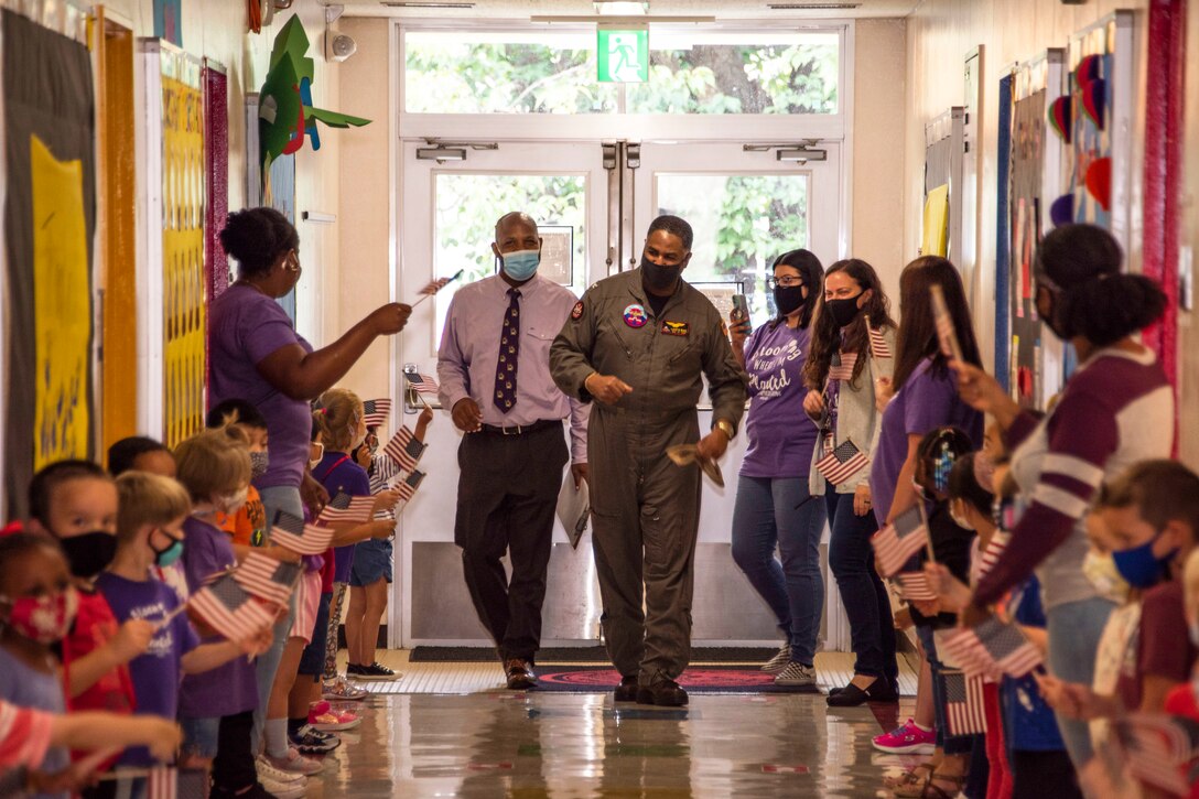 A Navy officer wearing a face mask completes a final walk through down a hallway at Shirley Lanham Elementary School.