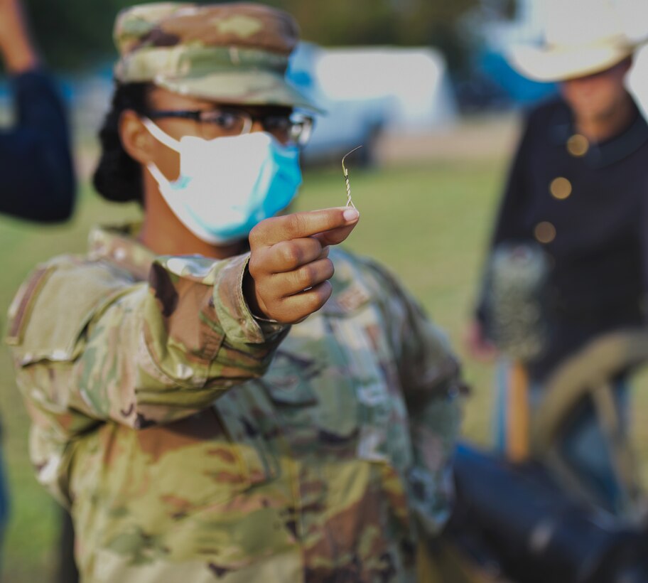 U.S. Airman 1st Class Mackenzie Parker, 315th Training Squadron student, displays the firing pin from a charge she fired during the Air Force Birthday Celebration on the Parade Field at Goodfellow Air Force Base, Texas, Sept. 18, 2020. After the official ceremony participants were welcome to walk around and look at historical memorabilia and fire the howitzer. (U.S. Air Force photo by Senior Airman Deven Schultz)