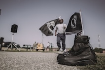 A black pair of boots sit on the base track Sep. 17, 2020, at Minot Air Force Base, North Dakota. About 250 volunteers that alternated shifts throughout the day and night, ran around the base track for 24 hours to honor those POW/MIA and concluded the run at 2 p.m. the next day. (U.S. Air Force photo by Airman First Class Jan K. Valle)