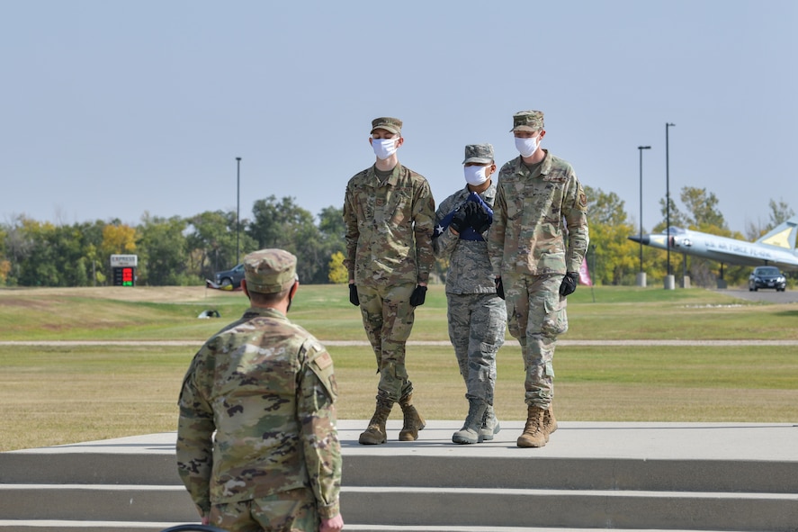 Team Minot honor guard fold a flag Sep. 17, 2020, at Minot Air Force Base, North Dakota. The base Honor Guard lowered the flag from the pole and performed a ceremonial flag folding presentation during the POW/MIA retreat.(U.S. Air Force photo by Airman First Class Jan K. Valle)