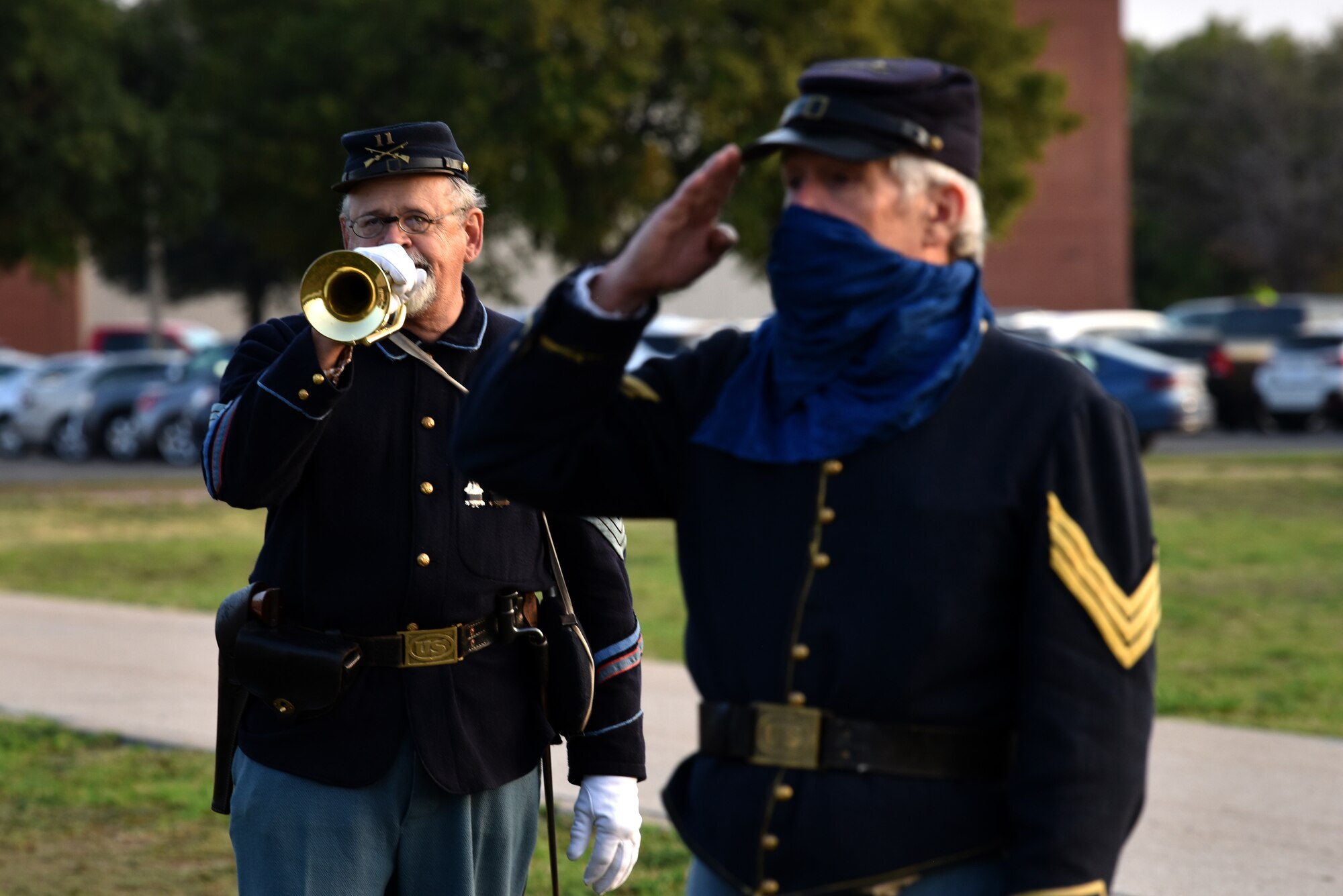 A Fort Concho National Historic Landmark re-enactor salutes the historical accurate 38-star flag while another re-enactor plays the bugle during the Air Force Birthday Celebration on the Parade Field at Goodfellow Air Force Base, Texas, Sept. 18, 2020. The re-enactors raised the flag to honor those who were the first to serve in all black regiments in the Army during the 19th century. (U.S. Air Force photo by Staff Sgt. Seraiah Wolf)