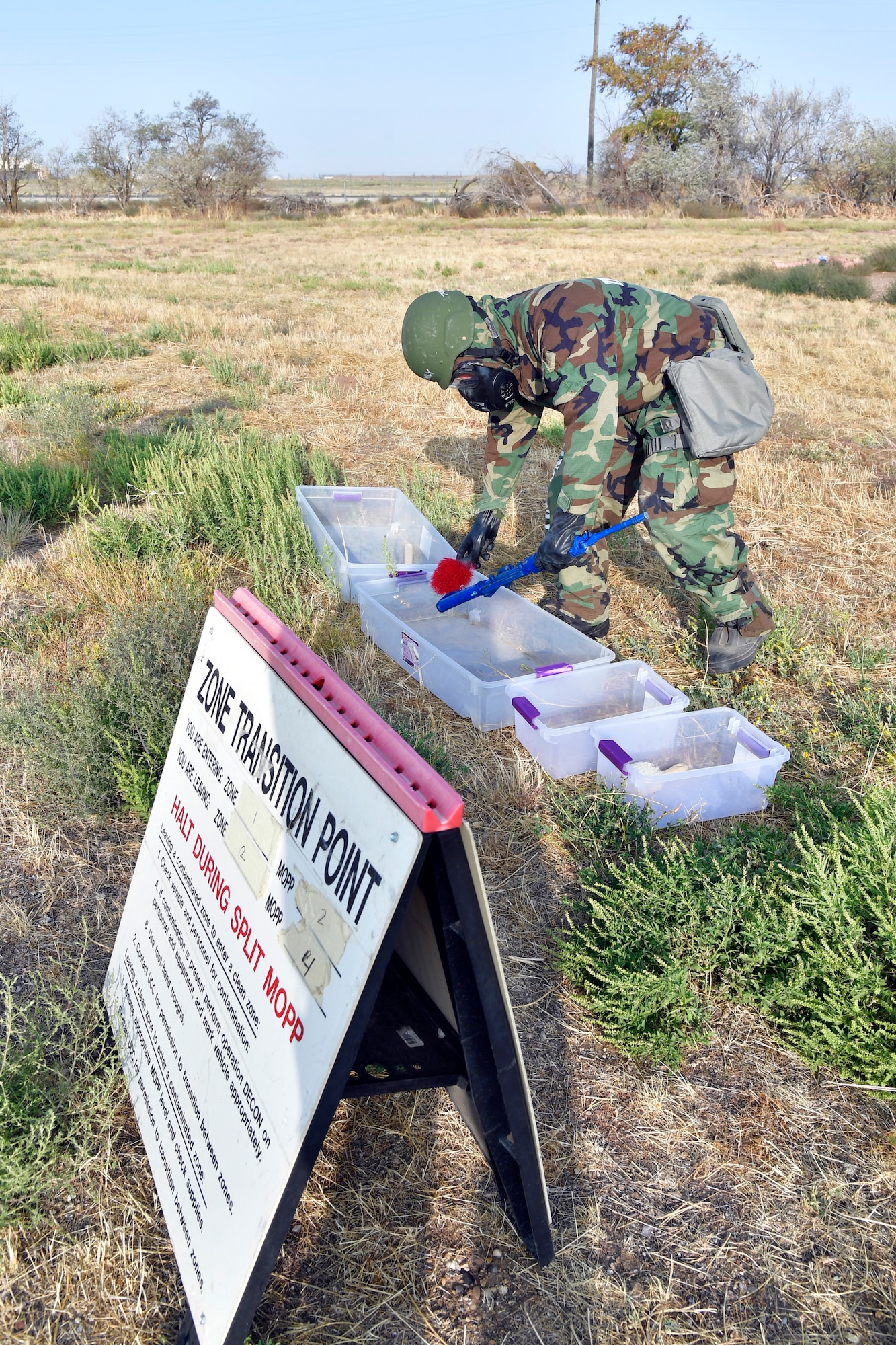 Airman 1st Class Jordan Vassallo, 75th Air Base Wing Communications and Information Directorate, simulates removing contamination from a weapon.
