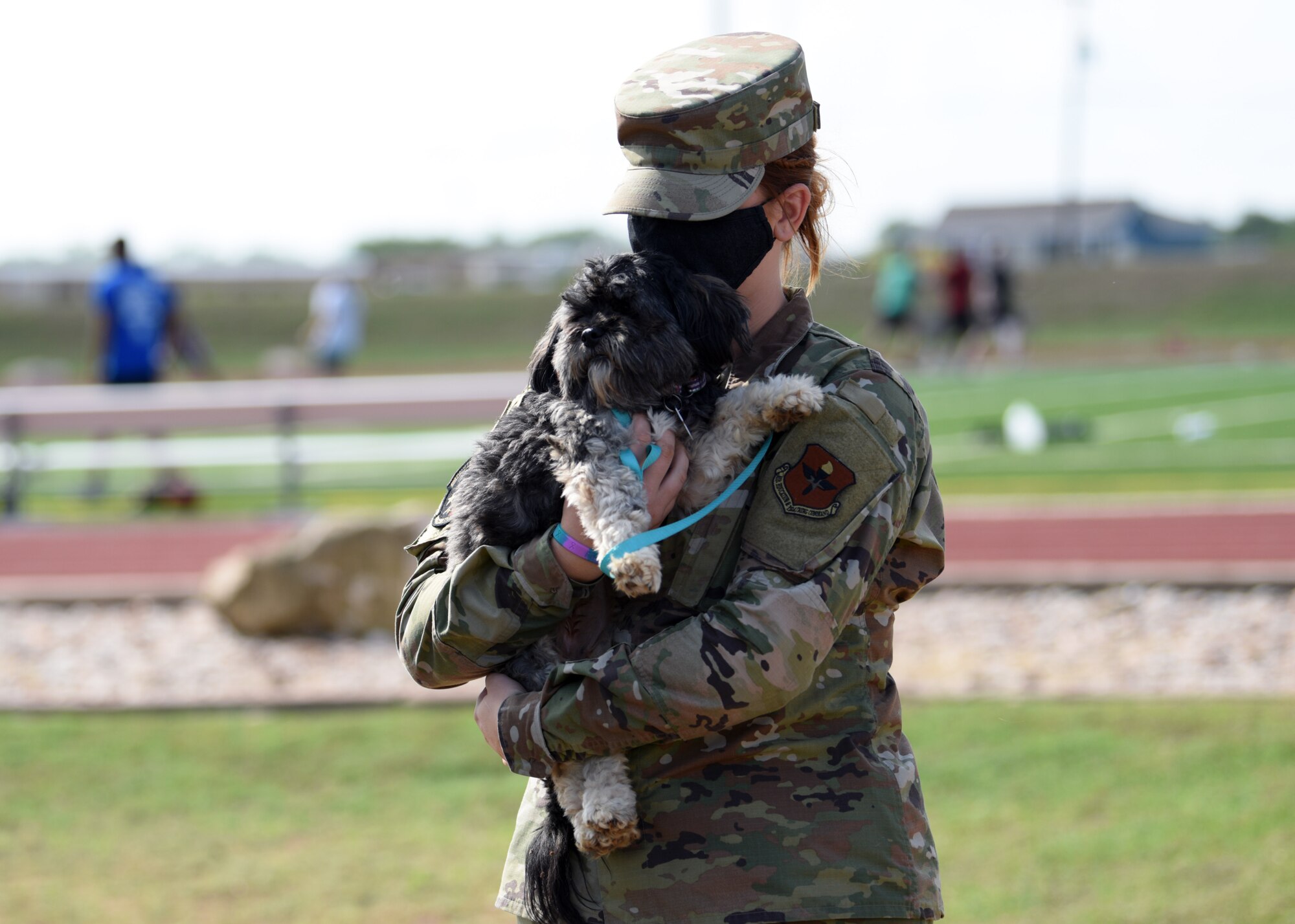 A member of Goodfellow holds a dog from Cassie’s Place at the Mathis Field Track on Goodfellow Air Force Base, Texas, Sept. 18, 2020. Dogs are periodically brought on base to aid in Goodfellow’s fight against suicide. (U.S. Air Force photo by Airman 1st Class Ethan Sherwood)