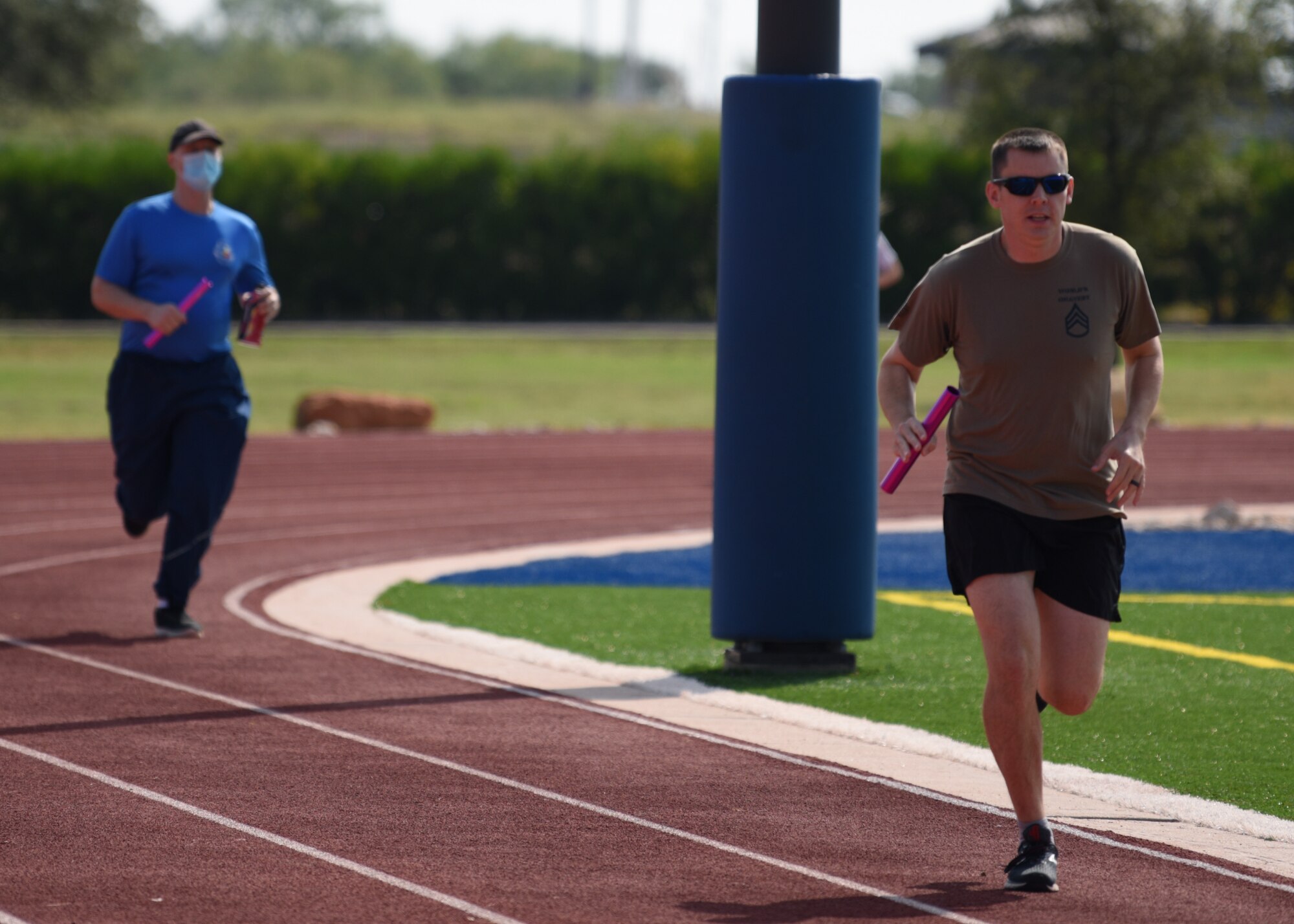 Participants run with batons around the track during the Suicide Awareness 24 Hour Run/Walk at the Mathis Field Track on Goodfellow Air Force Base, Texas, Sept. 18, 2020. The event celebrated life and encouraged participants to check on their wingmen. (U.S. Air Force photo by Airman 1st Class Ethan Sherwood)