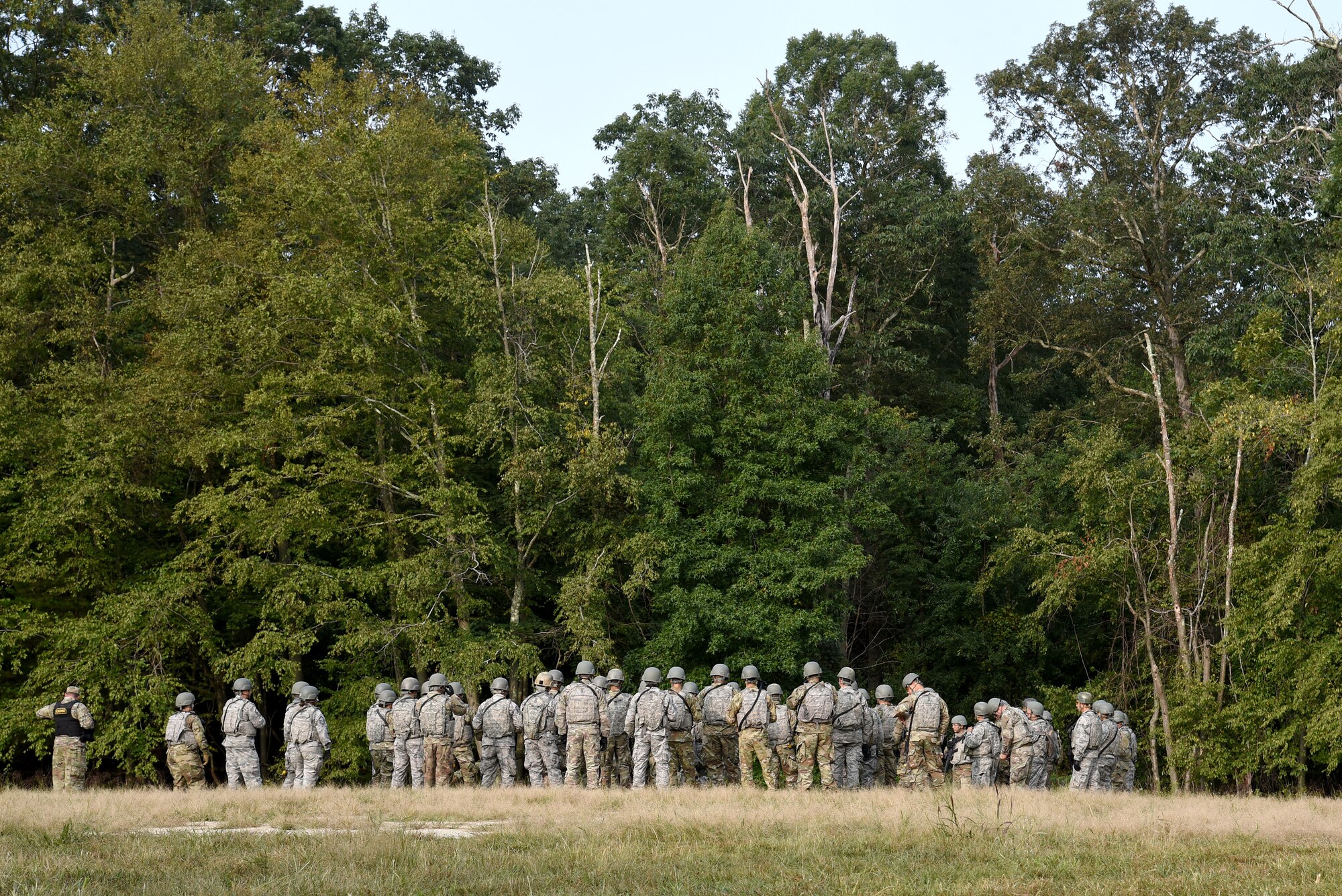 Photo of Airmen standing in a circle during Fieldcraft Contingency Response training.
