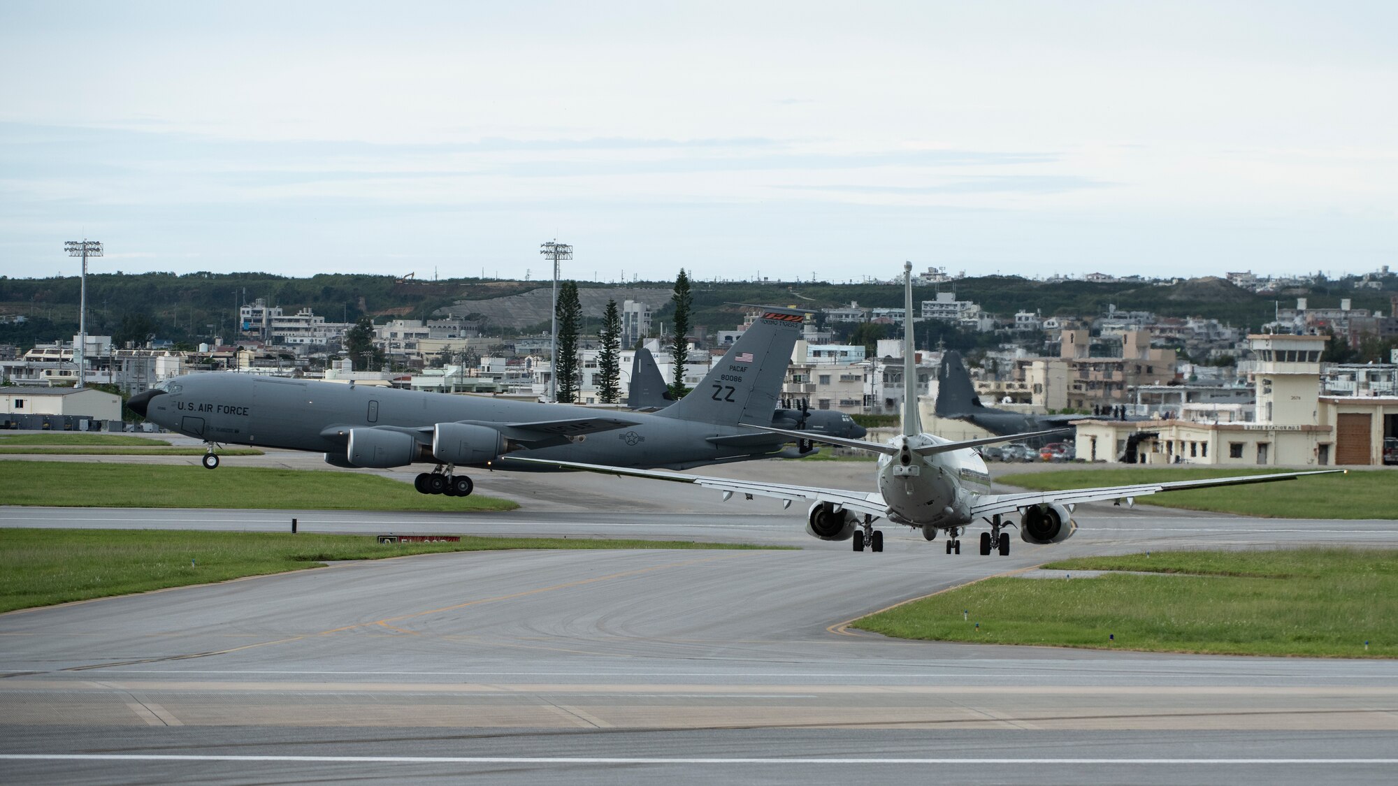 A U.S. Air Force 909th Aerial Refueling Squadron KC-135 Stratotanker conducts touch and go training while a U.S. Navy P-8A Poseidon stands by for taxi clearance Sept. 14, 2020, at Kadena Air Base, Japan. Team Kadena’s flexible multilateral operations capability enables combined, large force employment by U.S. and allied air units from anywhere in the world.