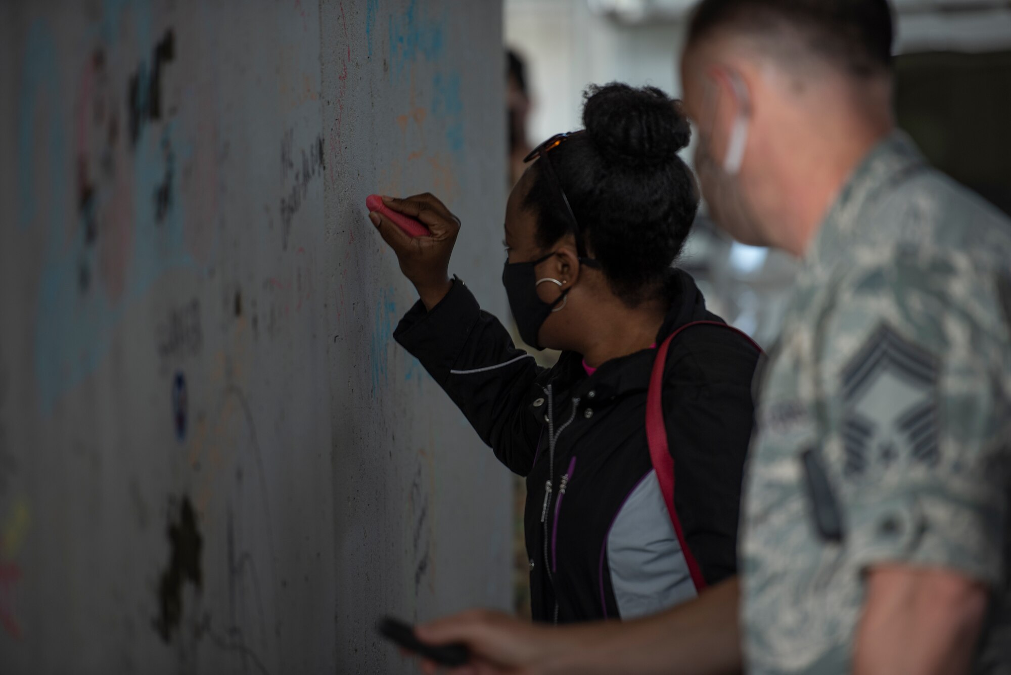 A civilian writes her name on the wall during the 73rd Air Force Birthday Celebration at Ramstein Air Base, Germany, Sept. 18, 2020.