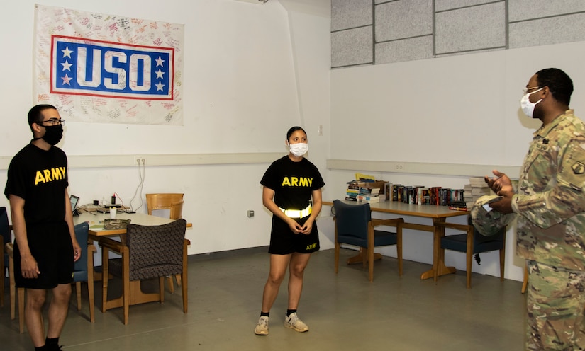 Spc. David Marable, right, speaks to Sgt. Yasmin Montufar and Spc. Joseph Acosta Gonzalez about exchange rates and phone applications at the Deployment Processing Center, Rhine Ordnance Barracks in Kaiserslautern, Germany September 11, 2020. The DPC currently houses incoming personnel from the United States undergoing quarantine and in-processing to the European theater. Task Force Willkommen is a group of organizations facilitating this process during the COVID-19 pandemic. (U.S. Army Reserve photo by Staff Sgt. Chris Jackson/Released)