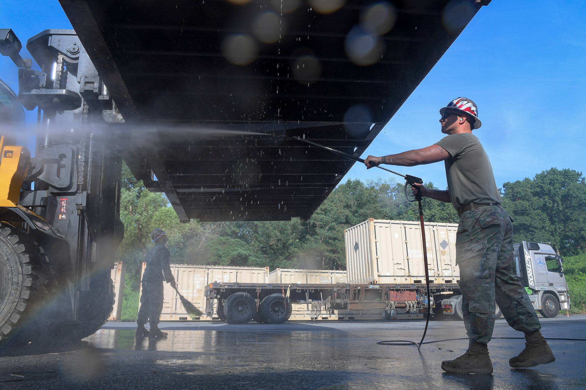 Staff Sgt. Michael Coyne, 51st Munitions Squadron shipping/receiving element crew chief, right, removes debris from cargo prior to a retrograde in support of operation “ammo transfer,” Aug. 25, 2020, in Pyeongtaek-si, Republic of Korea. The 51st MUNS and 51st Logistics Readiness Squadron transported excess serviceable assets valued at $13 million to Jinhae Port, Jinhae-gu, Republic of Korea, for international maritime shipping. (U.S. Air Force photo by Staff Sgt. Greg Nash)