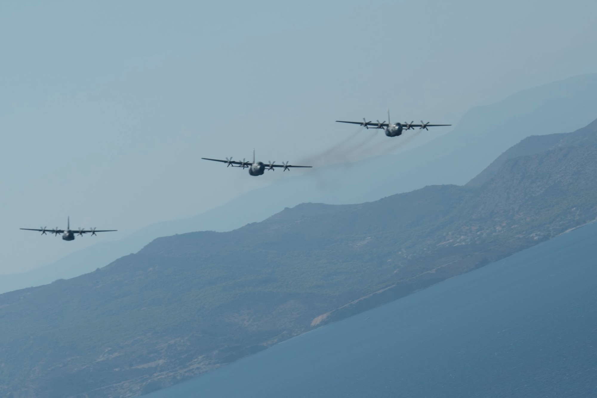 C-130J Super Hercules aircraft, one from the Hellenic armed forces and two assigned to the 86th Airlift Wing, fly over Megara Bay, Greece, during Operation Stolen Cerberus VII, Sept. 11, 2020. The exercise is designed to enhance readiness and demonstrate a shared commitment to a peaceful, stable and secure Europe. (U.S. Air Force photo by Airman 1st Class Taylor D. Slater)