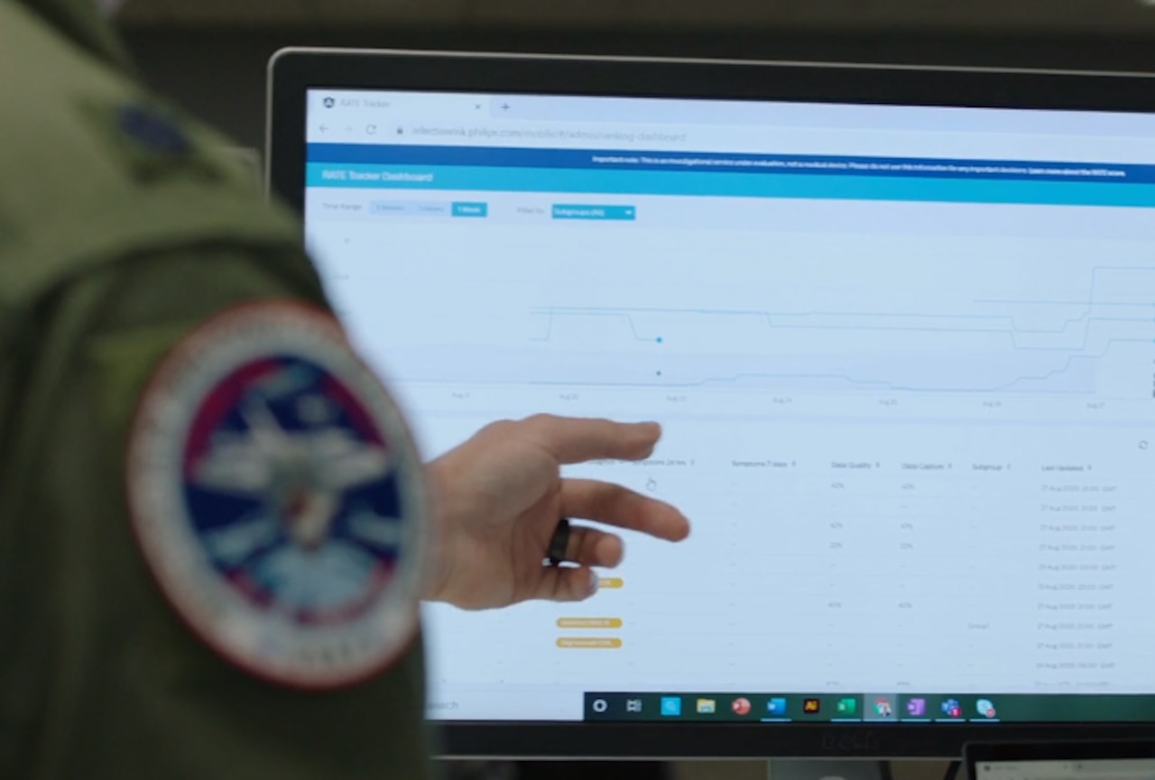 An airman points at a computer screen.