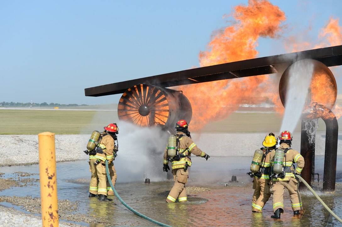 Firefighters spray water onto a fire.