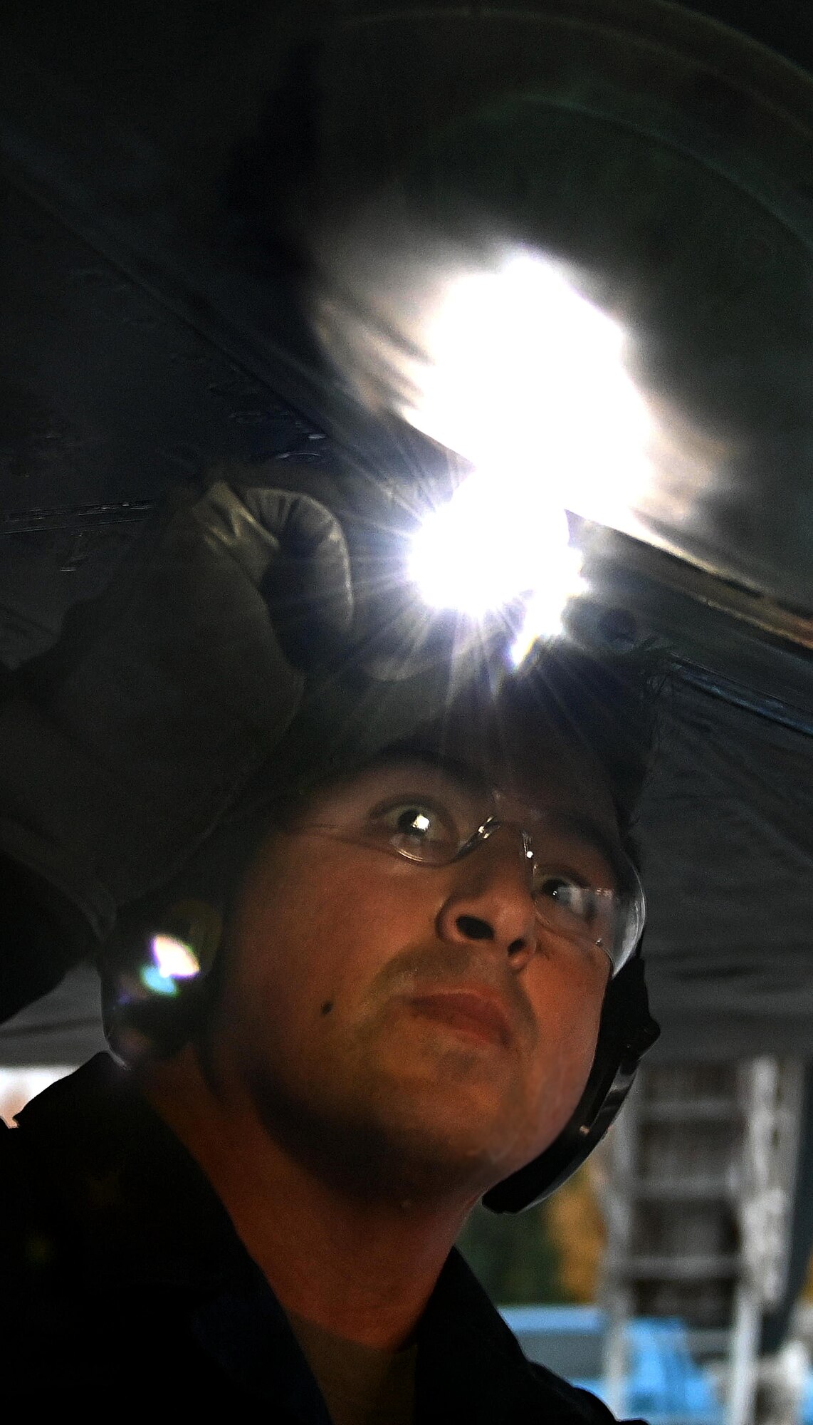 Photo of Airman inspecting B-1 with a flashlight