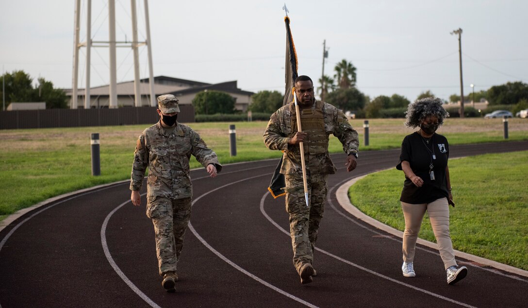 Chief Master Sgt. Robert L. Zackery III, 47th FTW command chief master sergeant, carries the prisoner of war and missing in action flag while walking around the track on Sept. 17, 2020 at Laughlin Air Force Base, Texas. The flag is a symbol of our Nation's concern and commitment to resolving, as fully as possible, the fates of Americans still prisoner, missing and unaccounted.