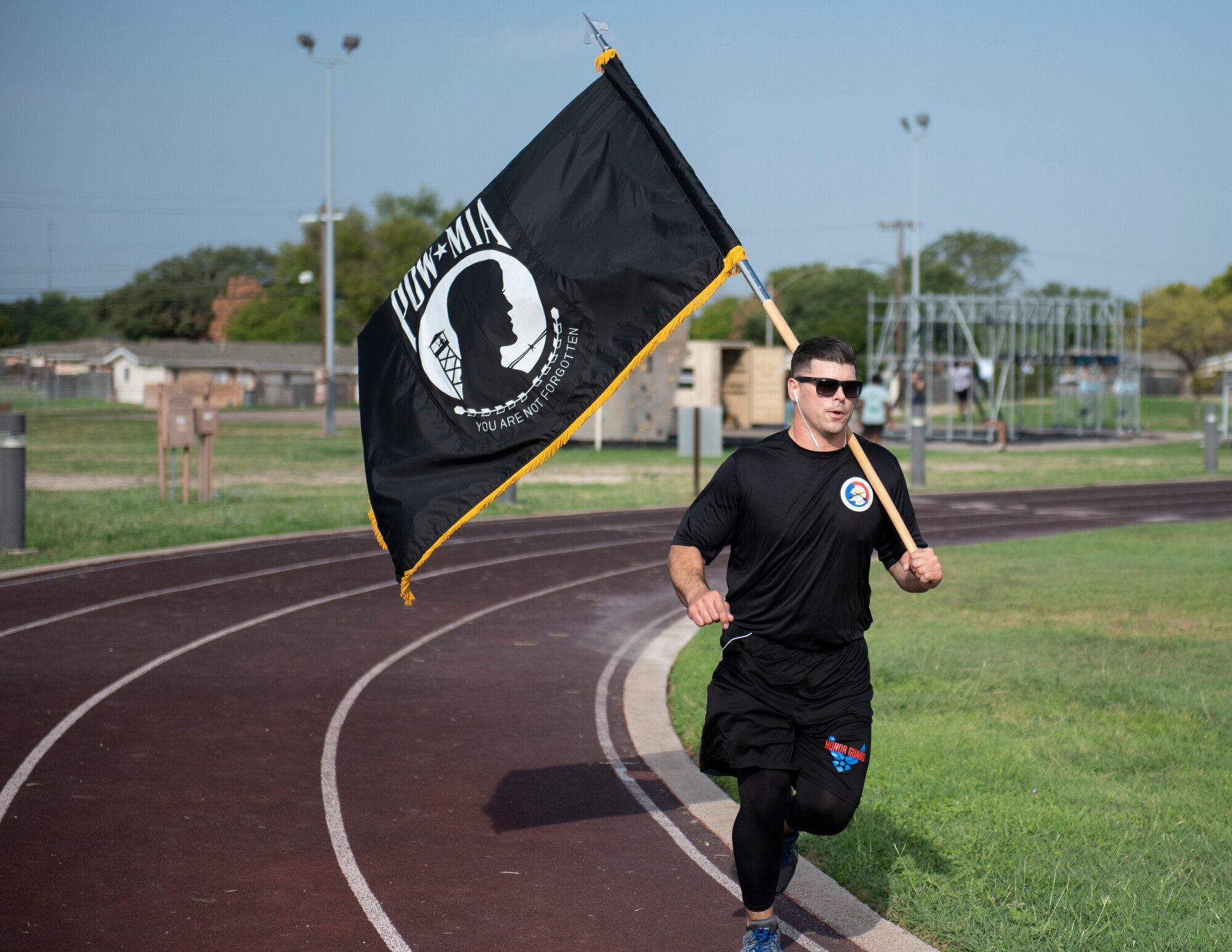 Tech. Sgt. Christopher Johnson, Honor Guard NCO in charge, runs around the track while carrying the prisoner of war and missing in action flag on Sept. 17, 2020 at Laughlin Air Force Base, Texas. Johnson ran the track while proudly carrying the flag to show his respect and raise awareness of POW/MIA military members.