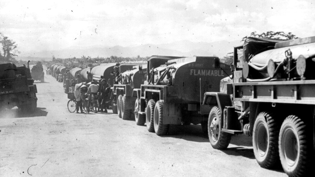 Black and white photo of fuel trucks in a line