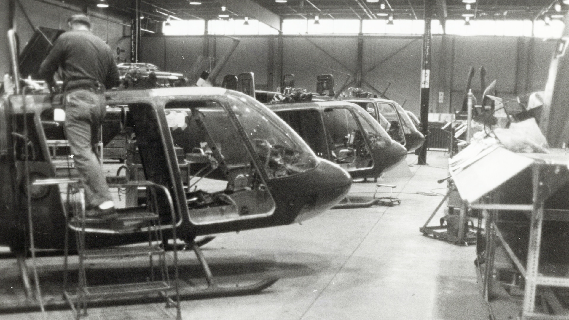 Black and white photos of helicopters in an assembly line