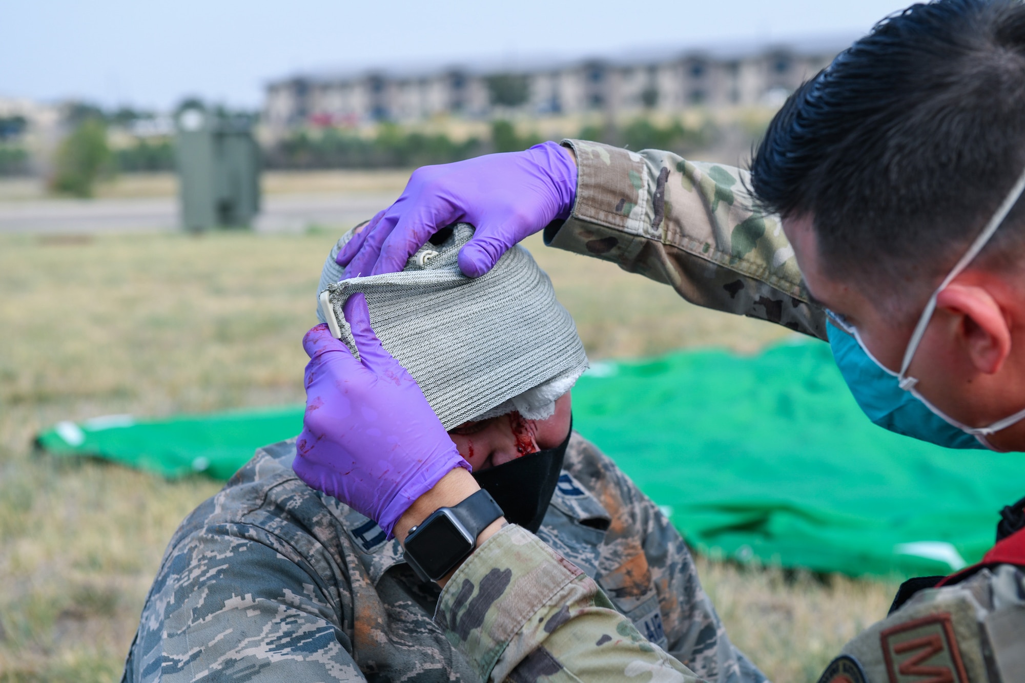 An Airman from the 460th Medical Group applies a bandage to a victim with a head wound during the Ready Eagle exercise where a simulated explosion occurred Sept. 18, 2020, at the Air Reserve Personnel Center on Buckley Air Force Base, Colo.