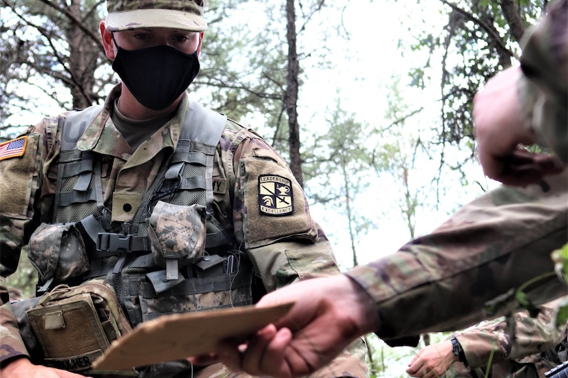 An ROTC cadet wearing a face mask training.
