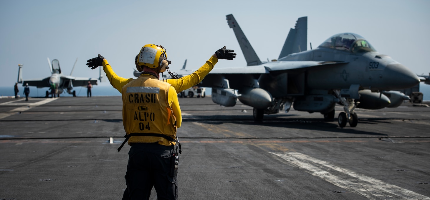 Sailors guide an E/A-18G Growler, assigned to the "Cougars" of Electronic Attack Squadron (VAQ) 139, on the flight deck of the aircraft carrier USS Nimitz (CVN 68) in support of Operation Inherent Resolve.