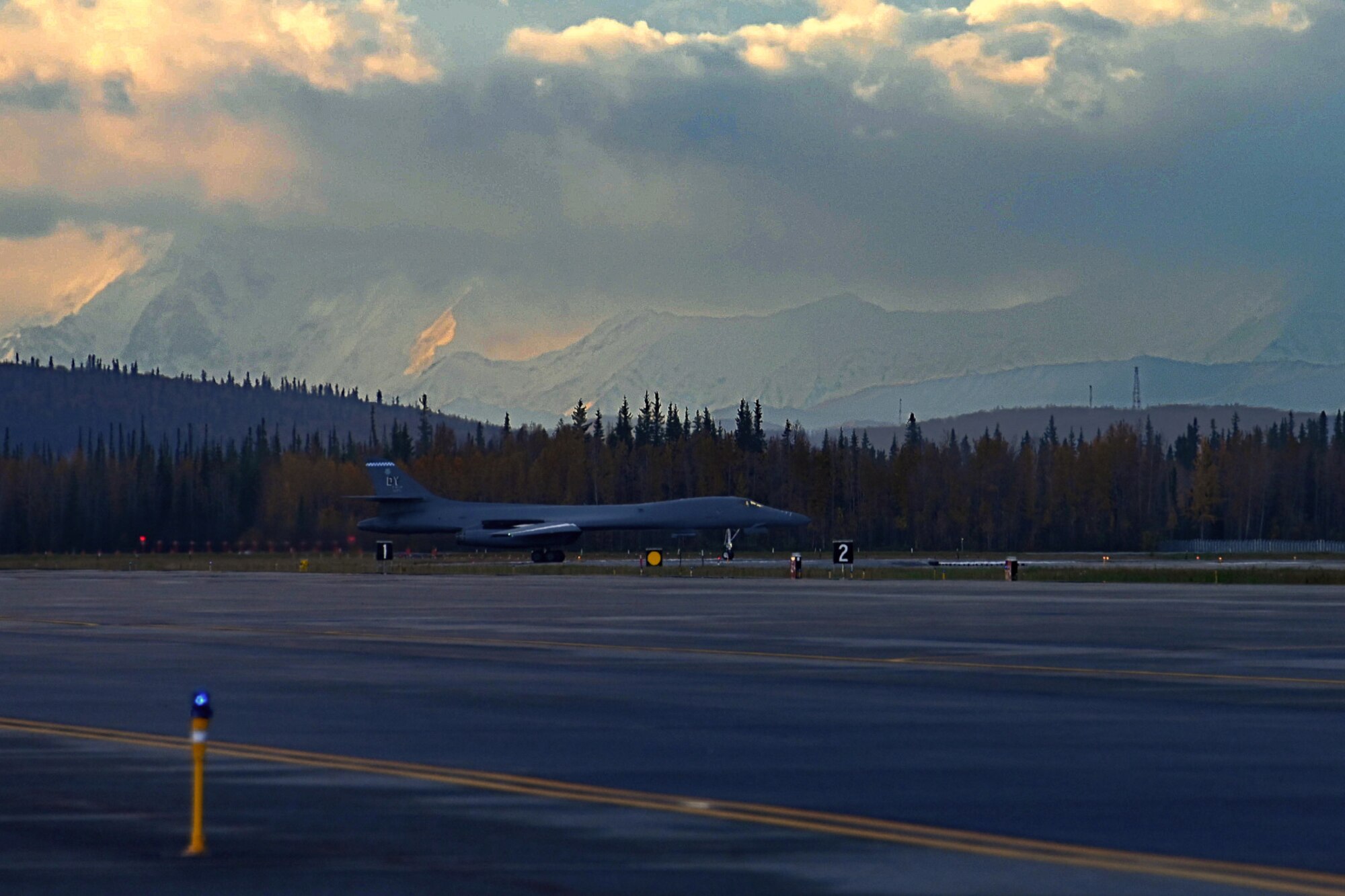 Photo of B-1 with snow-capped mountains in background