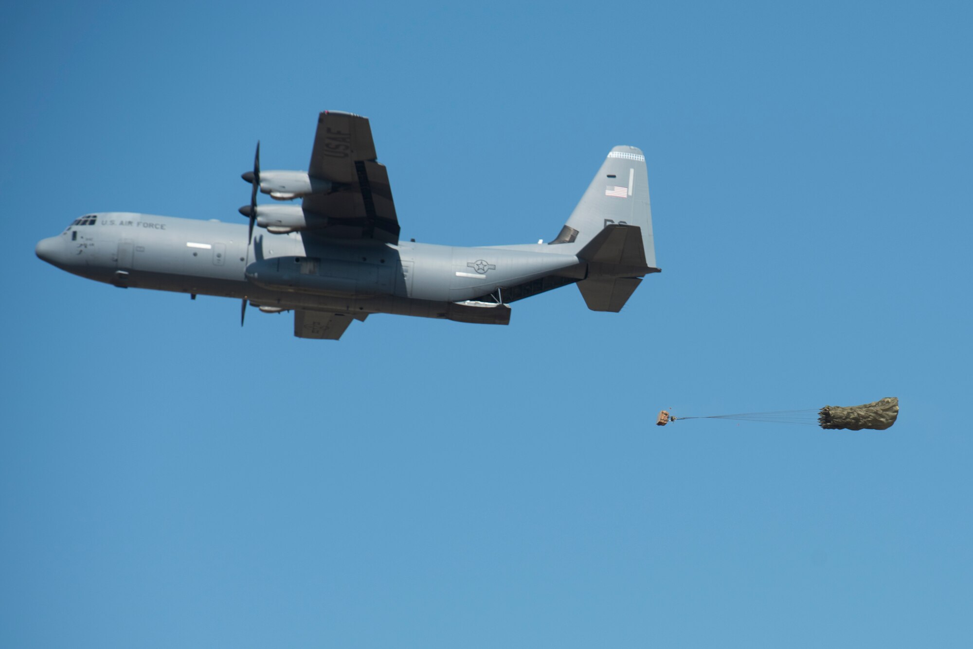 A C-130J performs a low cost low altitude airdrop.