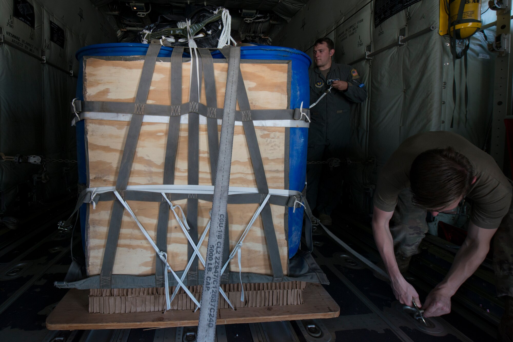Airmen secure a high velocity container delivery system to a C-130J aircraft.