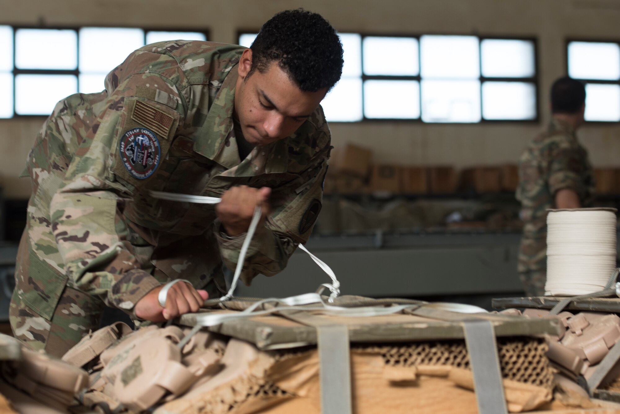 An Airman secures restraints on an airdrop.