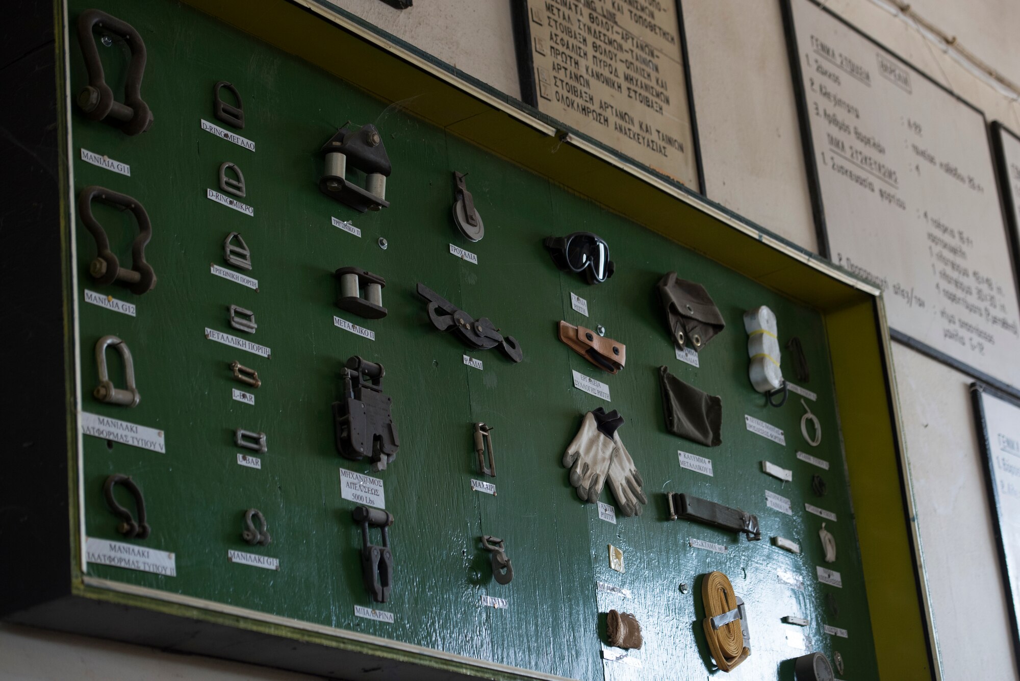 Rigger and paratrooper equipment is displayed on a wall.