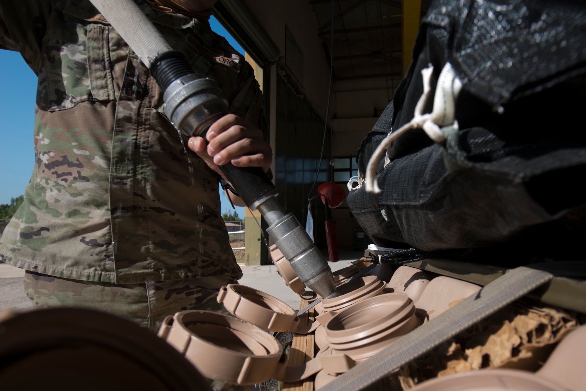 An Airman fills an airdrop with water.