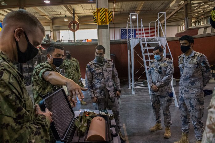 U.S. Coast Guard Maritime Law Enforcement Specialist 1st Class George Soto, middle left, assigned to Coast Guard Patrol Forces Southwest Asia (PATFORSWA), shows medical equipment used for visit, board, search and seizure (VBSS) operations to Saudi Arabian Border Guard Capt. Ali bin Madi Al-Qahtani, right, commander of Combined Task Force (CTF) 152, during a visit to the Coast Guard Maritime Engagement Team training facility on board Naval Support Activity Bahrain, Sept. 10. PATFORSWA is comprised of the Maritime Engagement Team, shoreside support personnel and six 110' cutters and is the Coast Guard's largest unit outside of the U.S., playing a key role in supporting the Navy’s maritime security and maritime infrastructure protection operations in the U.S. 5th Fleet area of operations.