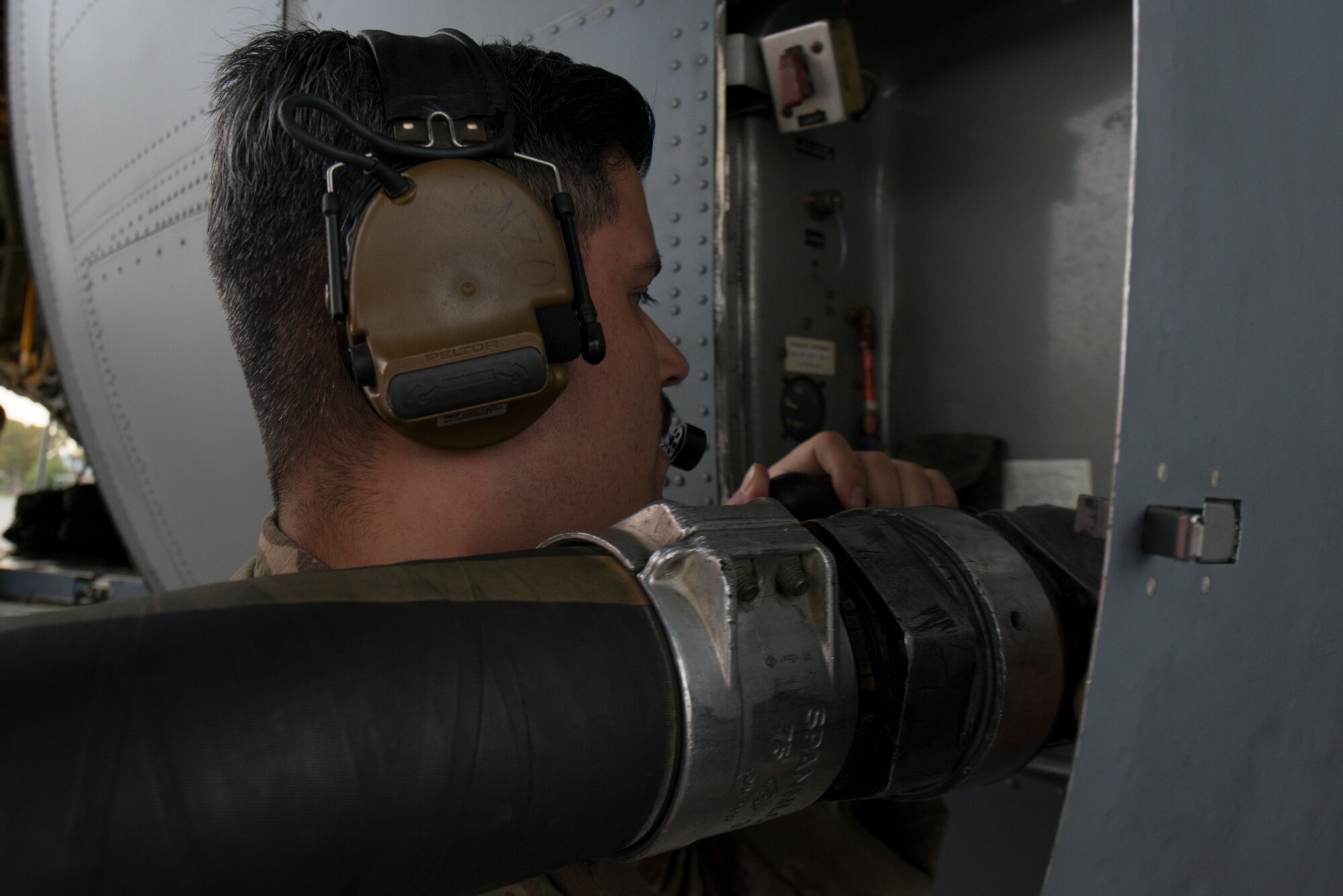 An Airman gives fuel to a C-130J aircraft.