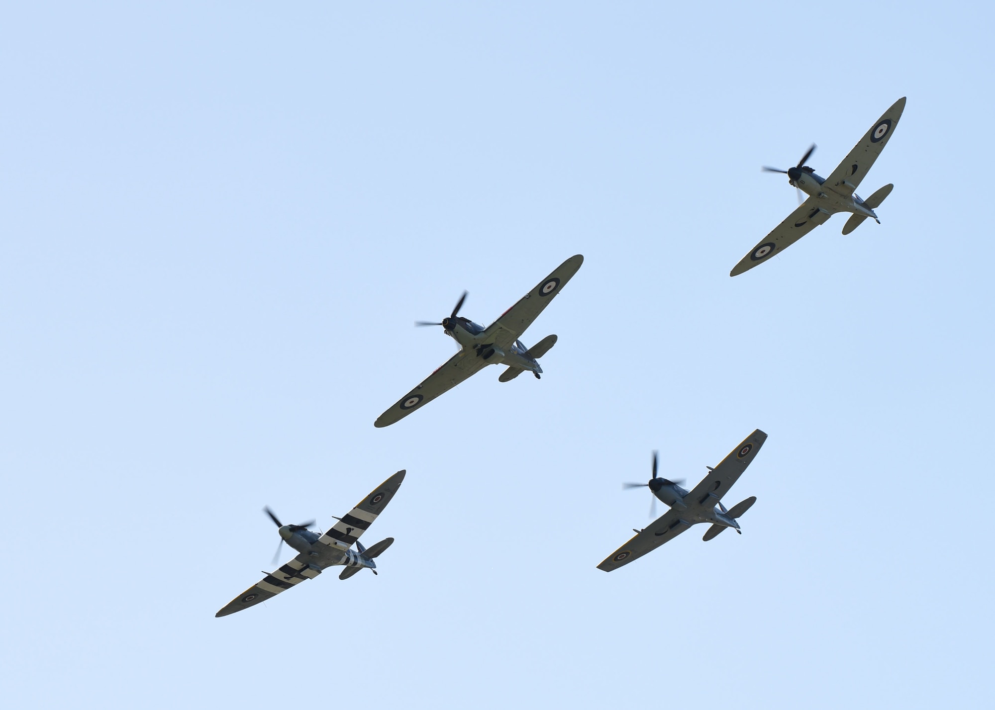 Three Royal Air Force Supermarine Spitfire aircraft and a Hawker Hurricane aircraft fly in formation as part of the U.S. Air Force's 73rd birthday and 80th anniversary of the Battle of Britain over RAF Mildenhall, England, Sept. 18, 2020. The celebration included the participation of F-15C Eagles, a CV-22B Osprey, MC-130J Commando II, KC-135 Stratotanker and the RAF Aerobatic Team. (U.S. Air Force photo by Karen Abeyasekere)