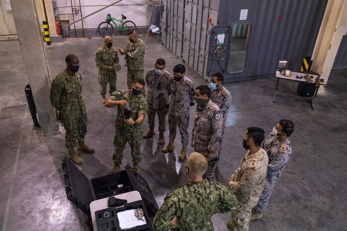 U.S. Coast Guard Maritime Law Enforcement Specialist 1st Class George Soto, middle, assigned to Coast Guard Patrol Forces Southwest Asia (PATFORSWA), shows equipment used for visit, board, search and seizure (VBSS) operations to members of the Saudi Arabian Border Guard and Combined Task Force (CTF) 152, during a visit to the Coast Guard Maritime Engagement Team training facility on board Naval Support Activity Bahrain, Sept. 10. PATFORSWA is comprised of the Maritime Engagement Team, shoreside support personnel and six 110' cutters and is the Coast Guard's largest unit outside of the U.S., playing a key role in supporting the Navy’s maritime security and maritime infrastructure protection operations in the U.S. 5th Fleet area of operations. (U.S. Navy photo by Mass Communication Specialist 3rd Class Dawson Roth)