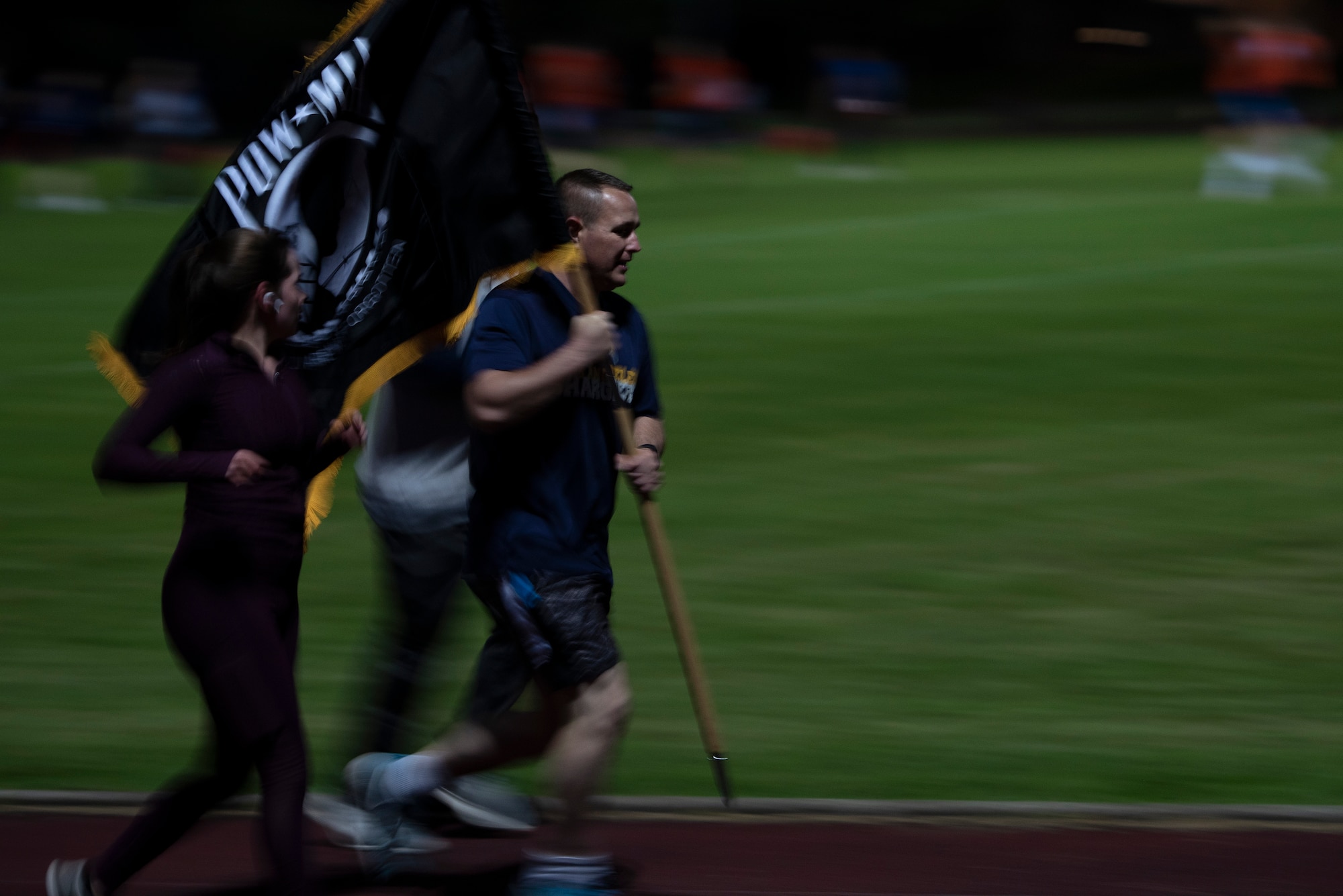 U.S. Air Force Master Sgt. Matthew Plew and Senior Airman Mikayla Whiteley, run with the POW/MIA flag at Royal Air Force Lakenheath, England, Sept. 17, 2020. Members of the 48th Fighter Wing kept the flag in constant motion for 24 hours in honor of more than 82,000 Americans who were Prisoners of War and Missing in Action from past conflicts. (U.S. Air Force photo by Airman 1st Class Jessi Monte)