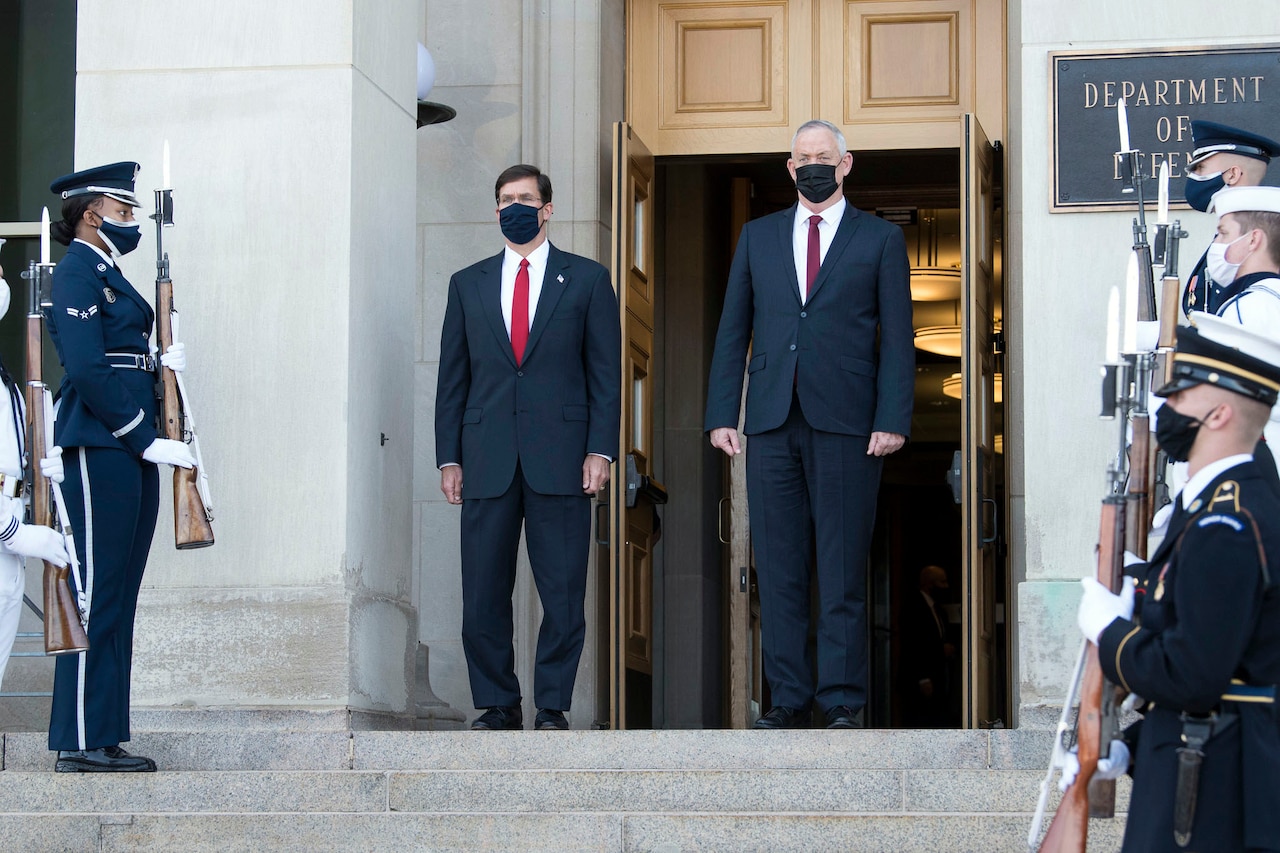 Two men wearing facemasks stand at the top of the Pentagon steps.