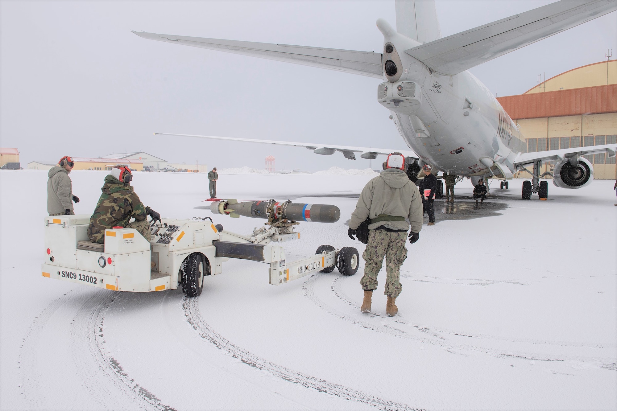 Personnel use a munitions handling unit to transport a torpedo to a P-8A Poseidon at Naval Air Station Keflavik.