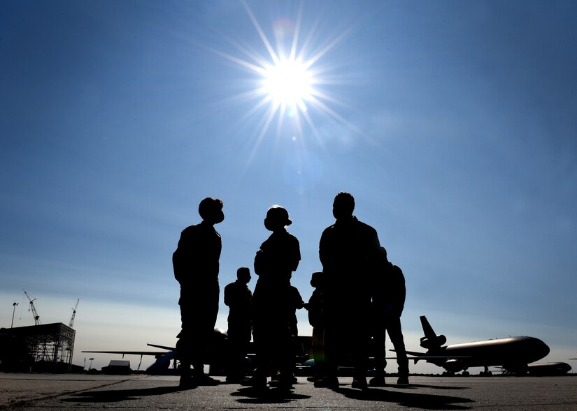 Photo of individuals talking on a flight line.