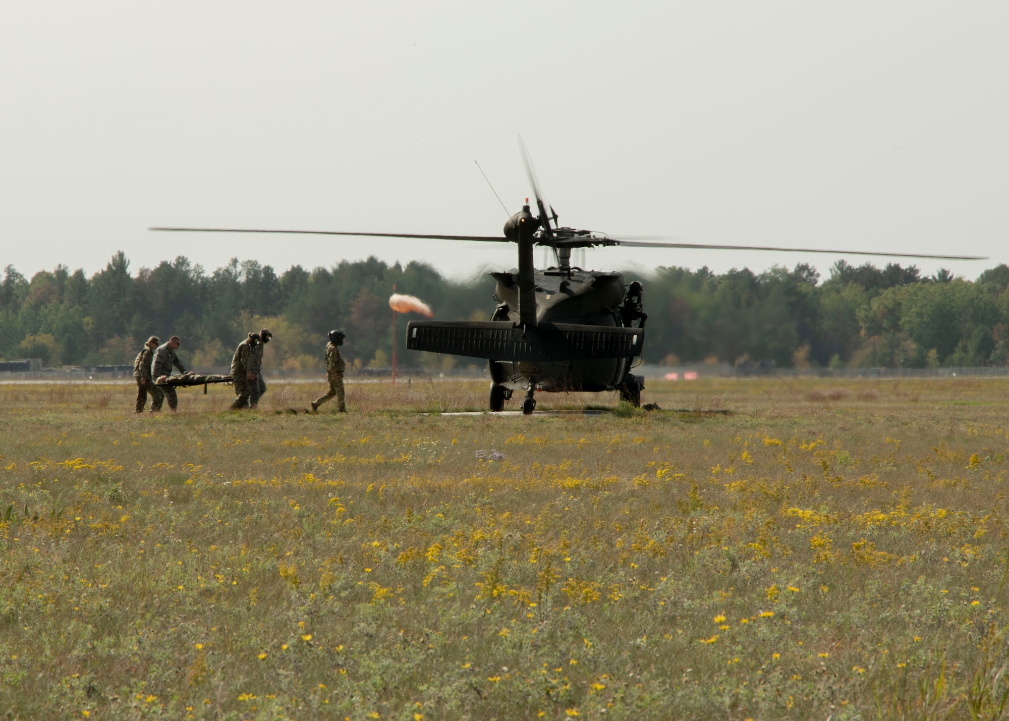 A group of Airmen from Minnesota Air National Guard's 148th Fighter Wing carry a litter during a joint medical exercise with the C Co 2-211, September 19, 2020 on Camp Ripley Training Center's helicopter landing pads.