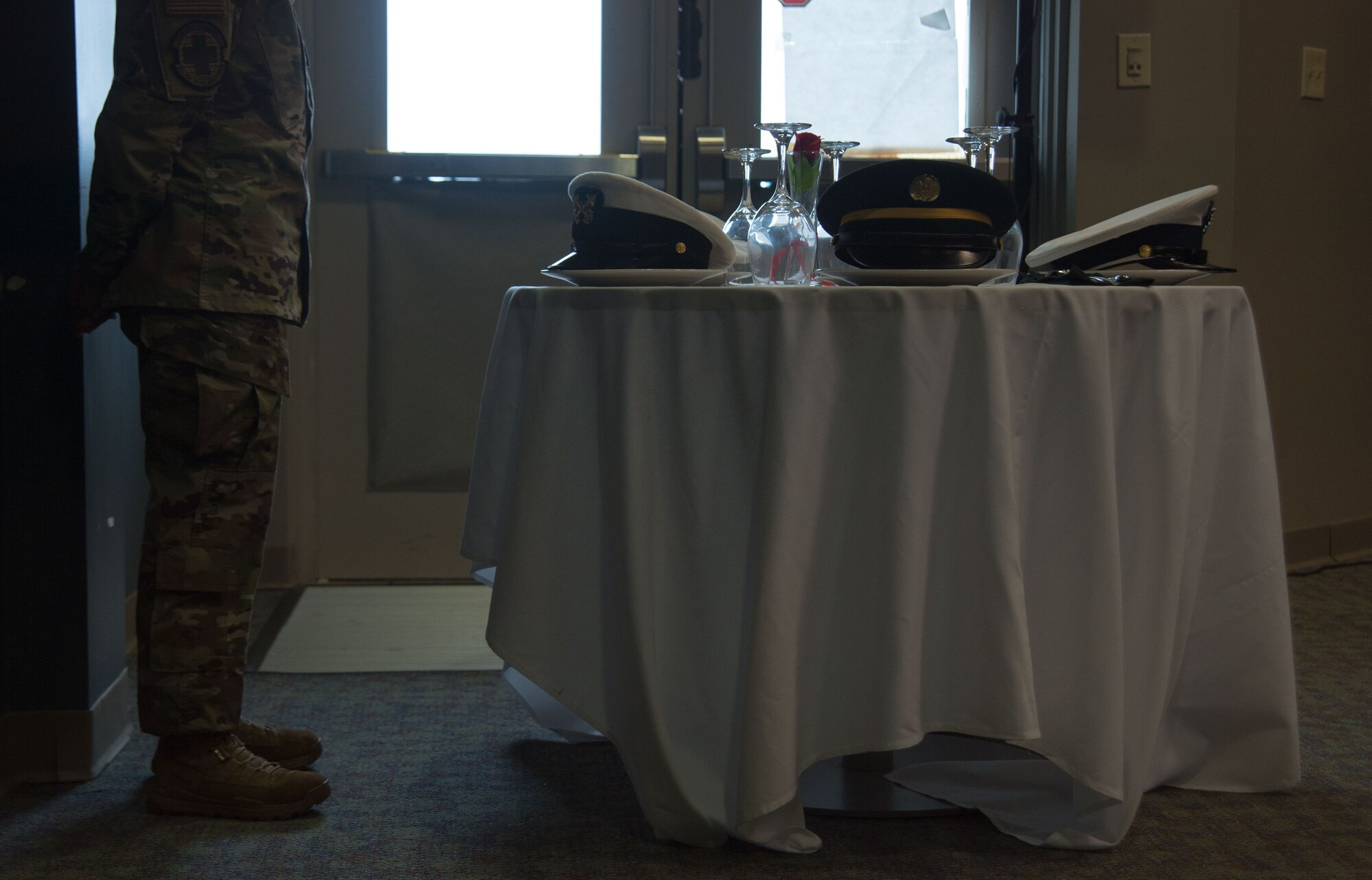 An Airman stands behind a table.
