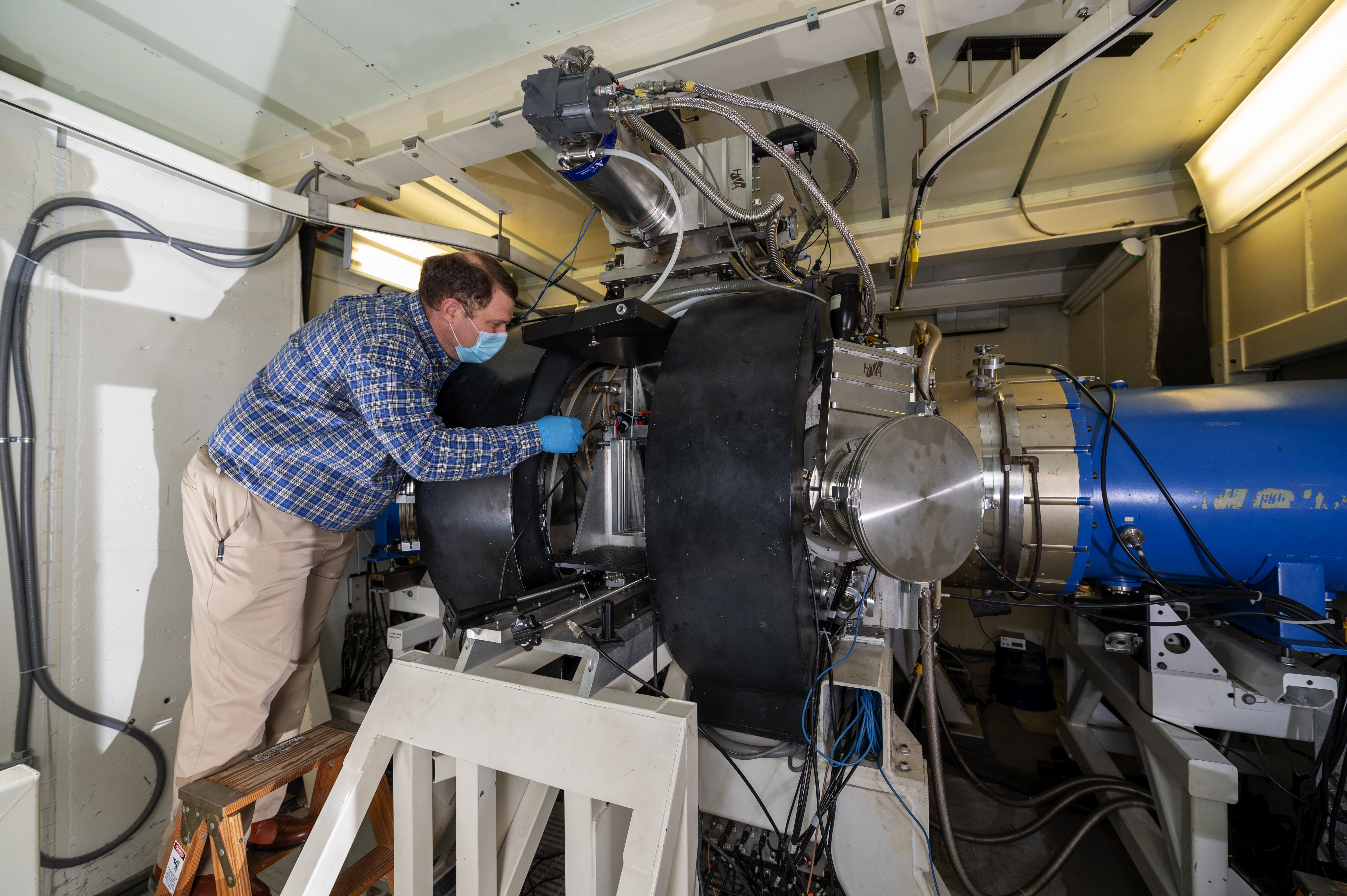 Matthew Wolford, a U.S. Naval Research Laboratory research chemist, inspects an argon fluoride (ArF) laser to be tested with new thicker stainless foils at Washington, D.C. June 1, 2020.