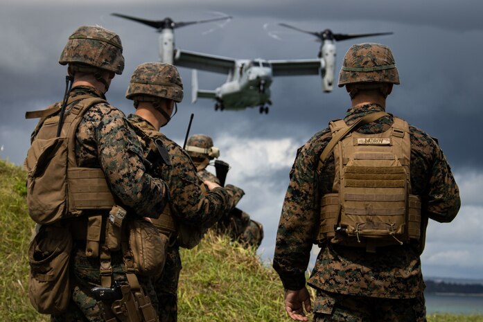 U.S. Marines observe an MV-22B Osprey prepare to land during a simulated embassy reinforcement at Kin, Okinawa, Japan, Sept. 12.