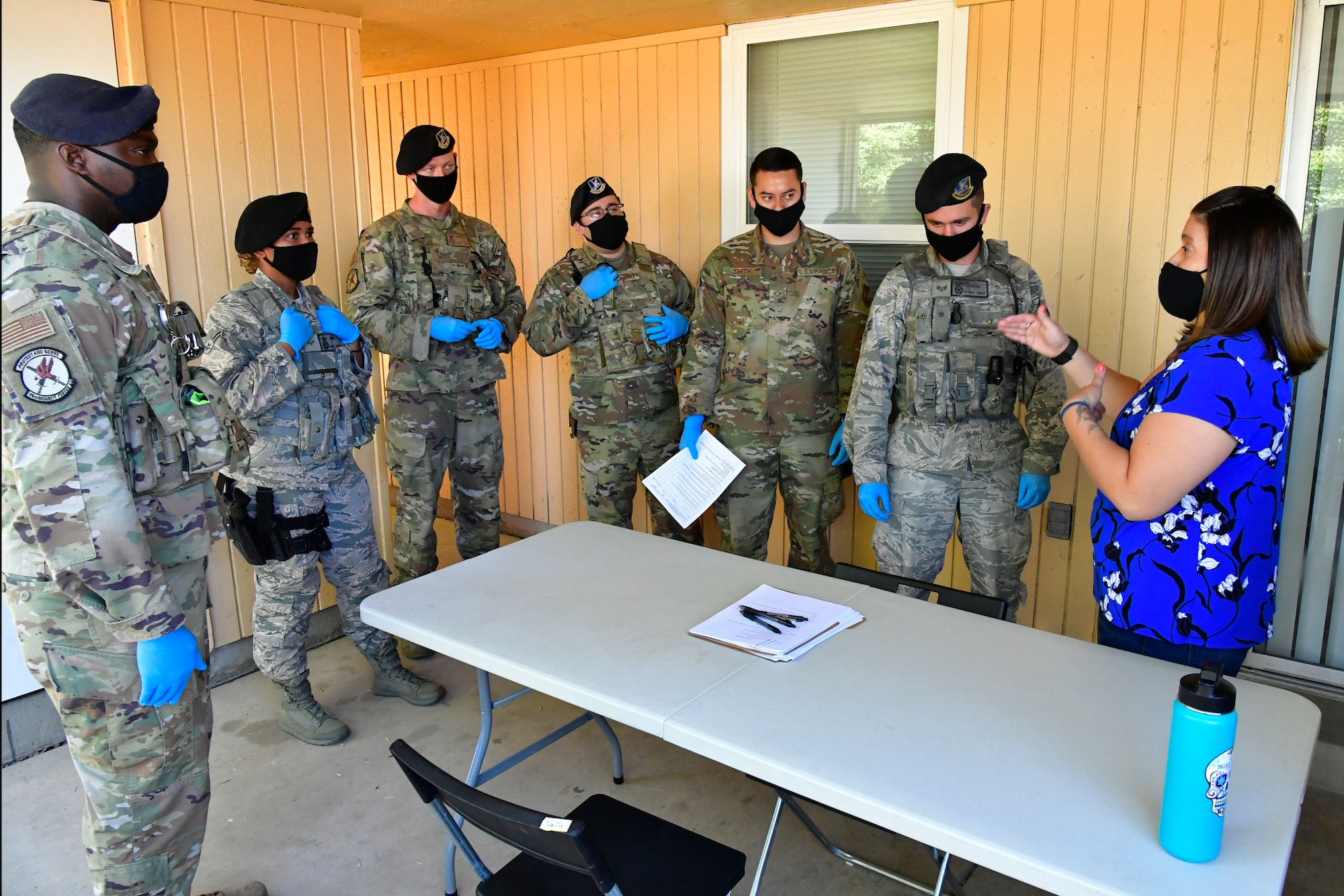 Tech. Sgt. Jaclyn Fessler (right), 75th Security Forces Squadron criminal investigator, reviews procedures with Airmen standing around her.