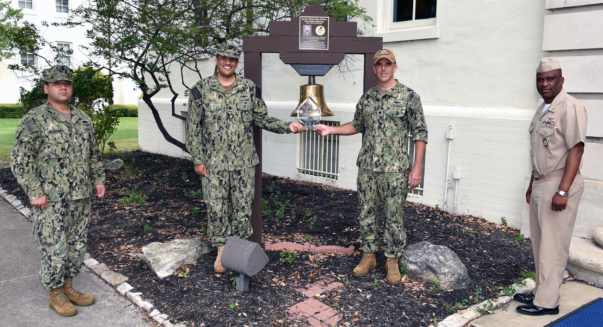 Cmdr. Nicholas Gamiz (right center), Navy Recruiting District San Antonio commanding officer, is joined by (from left) Command Master Chief Francisco Valdovinos, Cmdr. Michael Files, and Master Chief Matthew Maduemesi, along with the 2004 Navy Recruiting Command’s Bronze “R” Award at NRD-SA headquarters at Joint Base San Antonio-Fort Sam Houston.  The NRD was awarded the Bronze “R” by the Navy Recruiting Command for its performance during the first half of fiscal year 2020.